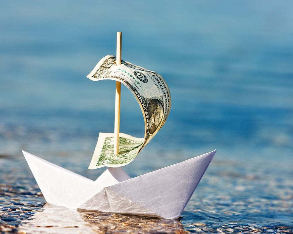paper sail boat with dollar bill for a sale
