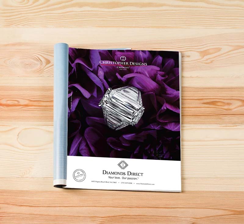 Diamonds Direct ad with large diamond ring on purple flower