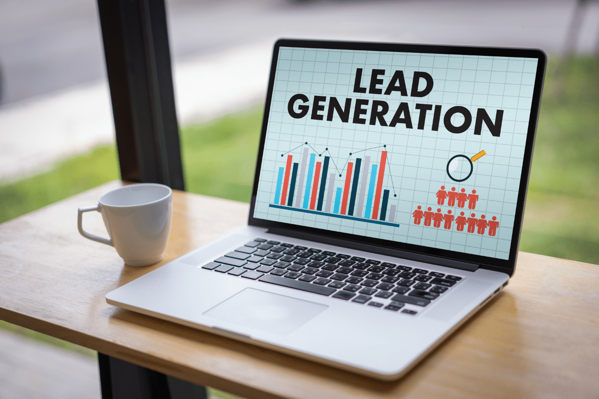 the words lead generation and a graph on the screen of a laptop sitting on a desk at a window with a mug